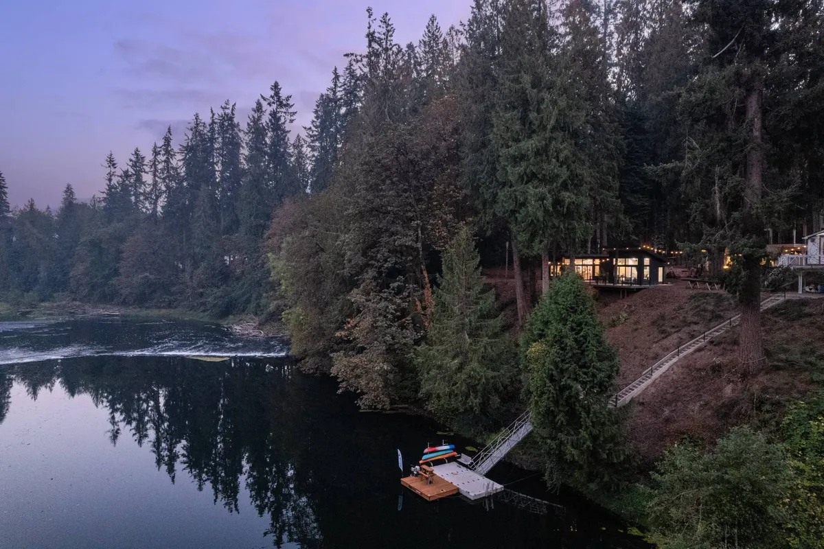 An exterior view captures the lake, dock, and the house itself, set in a serene landscape. The scene invites thoughts of boating, fishing, or gathering by the water, with a hint of the property’s communal charm and its lakeside lifestyle.